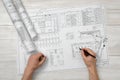 Hands of man holding a pencil over drawing layout in top view. Royalty Free Stock Photo
