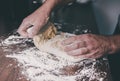 Hands of man kneading yeast dough on floured kitchen counter Royalty Free Stock Photo