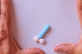 Hands of a man next to pills that symbolize a penis with an erection. Metaphor of male virility. Medicine related to male