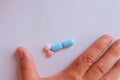 Hands of a man next to pills that symbolize a penis with an erection. Metaphor of male virility. Medicine related to male