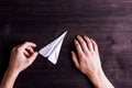 Hands of man, paper plane. Wooden background. Studio shot. Royalty Free Stock Photo