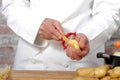 Hands of a man peeling potato with peeler Royalty Free Stock Photo