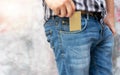 Hands of man pick up empty gold generic credit card out of jeans pocket. Concept of losing money, business and finance Royalty Free Stock Photo