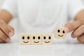 hands of man pick up selection wooden cube blocks with smile emotion icons. Royalty Free Stock Photo