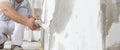 Hands man plasterer construction worker at work with trowel, plastering a wall, closeup