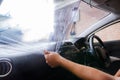 Hands of man removing old car window film with foggy spray Royalty Free Stock Photo