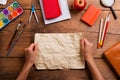 Hands of man with rumpled paper. Various school supplies.