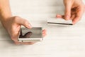 Hands of a man smartphone and credit card in the on a white back