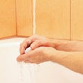 Hands of man with soap under running water in bathroom Royalty Free Stock Photo