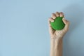 Hands of a man squeezing a green stress ball on the blue table background in the office Royalty Free Stock Photo
