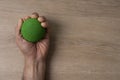 Hands of a man squeezing a green stress ball on the table in the office Royalty Free Stock Photo