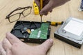 Hands of a man taking apart a broken hard disk. Technology and services Royalty Free Stock Photo