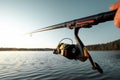 Hands of a man in a Urp plan hold a fishing rod, a fisherman catches fish at dawn. Fishing hobby vacation concept. Copy space Royalty Free Stock Photo