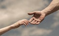 Hands of man and woman on blue sky background. Lending a helping hand. Giving a helping hand. Solidarity, compassion Royalty Free Stock Photo