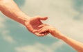 Hands of man and woman on blue sky background. Lending a helping hand. Solidarity, compassion, and charity, rescue