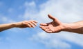 Hands of man and woman on blue sky background. Lending a helping hand. Solidarity, compassion, and charity, rescue Royalty Free Stock Photo
