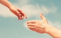 Giving a helping hand. Hands of man and woman on blue sky background. Lending a helping hand. Solidarity, compassion Royalty Free Stock Photo