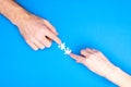 Hands of man and woman collect puzzles on a blue background background. Conceptual image of joint cooperation in the family. View