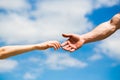 Hands of man and woman reaching to each other, support. Hands of man and woman on blue sky background. Giving a helping Royalty Free Stock Photo