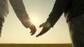 Hands of man and woman at sunset. sunny glare through palms. loving couple holding hands at sunset. Extend your hand to