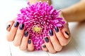 Hands with manicure and pink flower