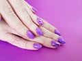 Hands manicure violet polish trendy design on colored paper fashionable glamour minimal