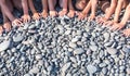 The hands of many children form a semicircle on the beach.