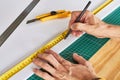 Hands marking a white board, ruller and pencil on a green mat and wooden table Royalty Free Stock Photo