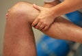 Hands massaging athlete's thigh after running