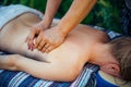 Hands masseur on the back of patient close-up. Woman on massage treatments at the Spa outdoor. Relaxed woman receiving wellness Royalty Free Stock Photo