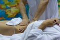 Hands of the masseur and the client`s body during massage treatm