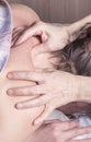 The hands of the masseur massage the collar area of the patient`s back Royalty Free Stock Photo