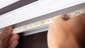 hands master install LED strip lighting in the niche of the cabinet to illuminate the wardrobe Royalty Free Stock Photo