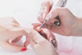 The hands of the master of manicure and the hands of the client close-up during the nail design process.