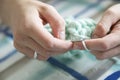 Hands of a master seamstress at work, knitting.