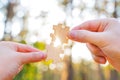 Hands matching jigsaw puzzle pieces at sunset