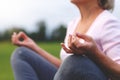 Hands of mature woman practicing yoga