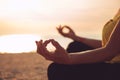 Hands of mature woman practicing yoga