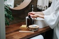 Hands of a mature woman pumping an eco soap from a bottle