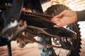 Hands, mechanic and motorbike chain in repairs working on springs or timing for safety or mechanical parts. Hand of