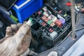 The hands of the mechanic replacing the fuse in the car. The mechanic selects the correct fuse. selective focus