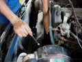 Hands of mechanic with wench checking car in garage. Auto repair service.