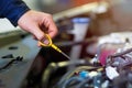 Mechanic checking engine oil in auto repair shop