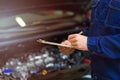 Mechanic working on car engine in auto repair shop