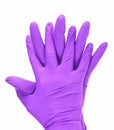 Hands of a medic wearing violet latex gloves, white background