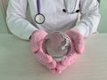 Hands in medical gloves hold transparent globe