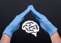 Hands with medical gloves protecting a brain