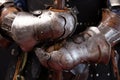 Hands of a medieval knight in iron protective gauntlets holding a spear Part of the military uniform