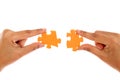 Hands merging two jigsaw puzzle pieces against white Royalty Free Stock Photo