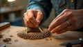 Hands meticulously crafting intricate chainmail jewelry with precision tools and artistic skill in a jewelry workshop setting Royalty Free Stock Photo